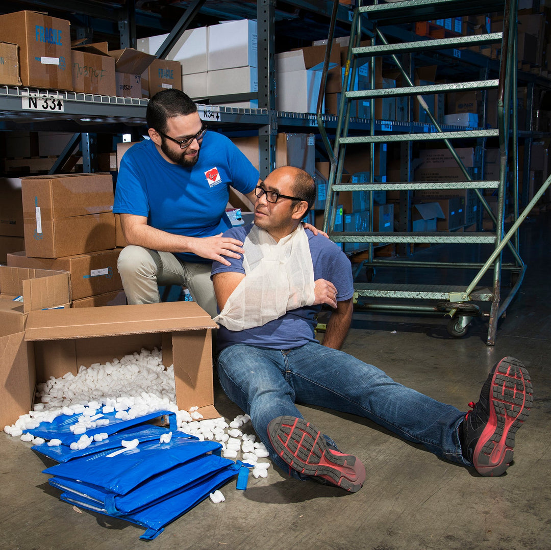 Two men in a warehouse setting with boxes and pallets.